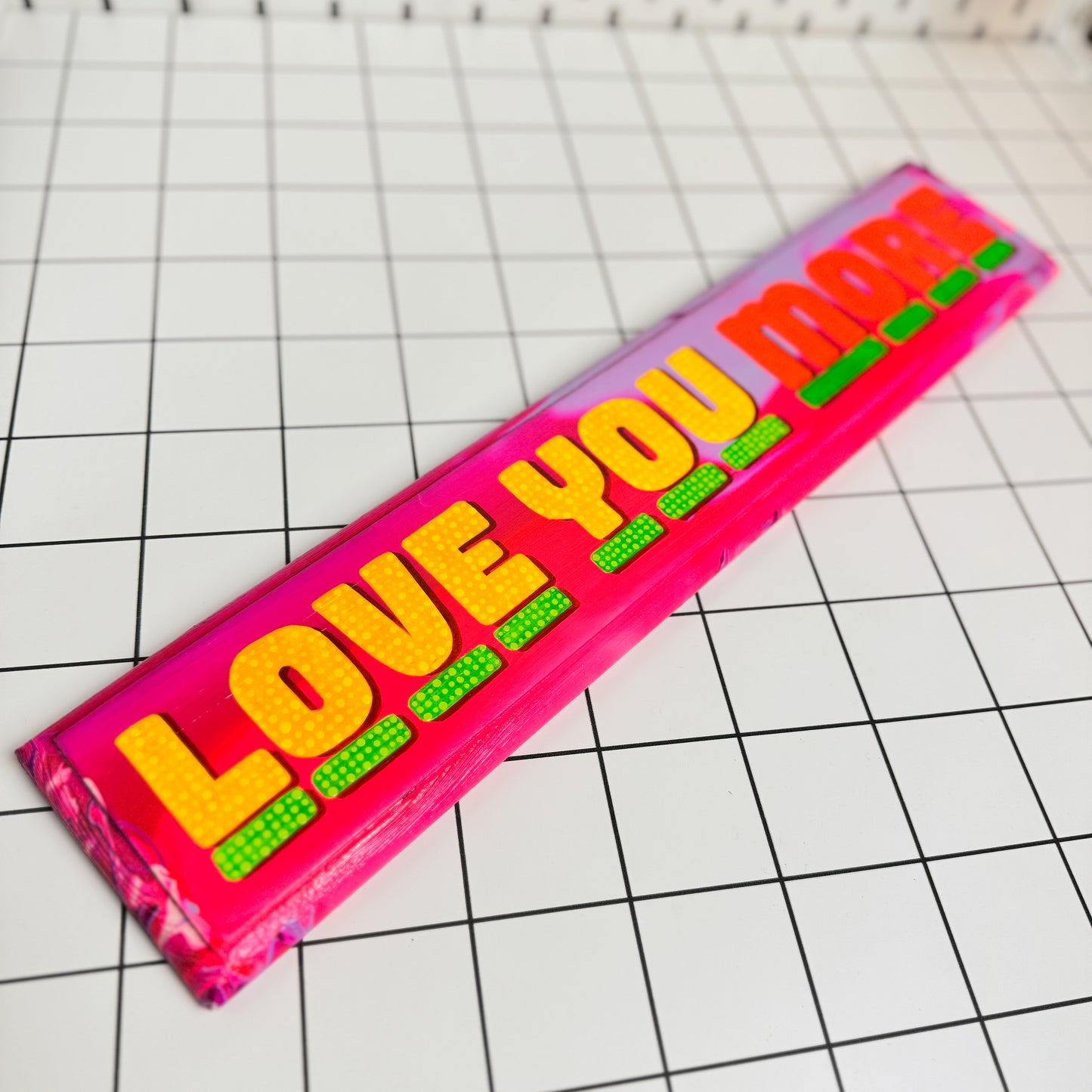 Alternative view of Stoofy's hand-painted “Love You More” sign with bold lettering and vibrant colours on wood by artist, Stoofy. Human-made, contemporary maximalist art for bold interiors.