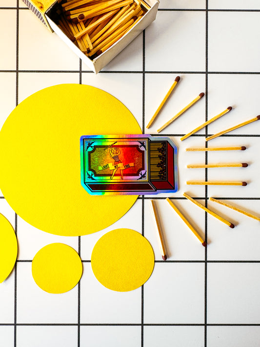 Styled shot of Stoofy's die cut vinyl sticker holographic pin up vintage sailor Jerry tattoo light my fire swallows matchbox matchsticks sticker head. Design and copyright owned by Stoofy.