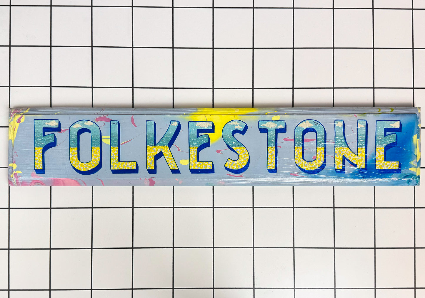 Hand-painted "Folkestone" wooden sign in vibrant colours – a bold tribute to the Kent coast. Original wall art with vintage charm and Stoofy character.