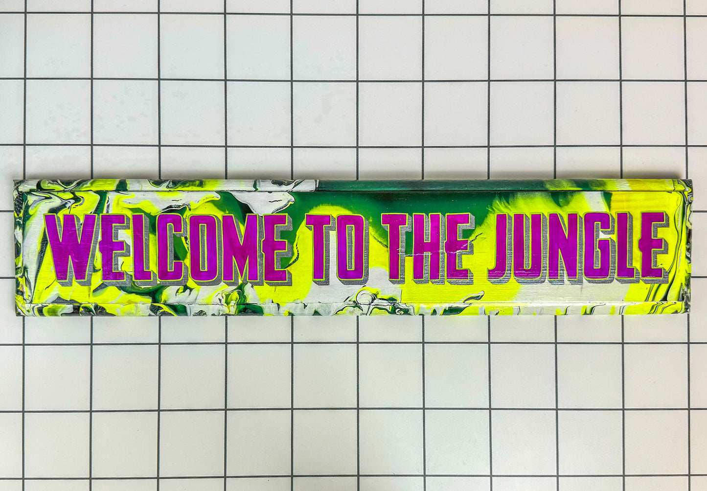 Hand-painted ‘Welcome to the Jungle’ sign with green background, animal print, and bold lettering, finished in gloss by Stoofy