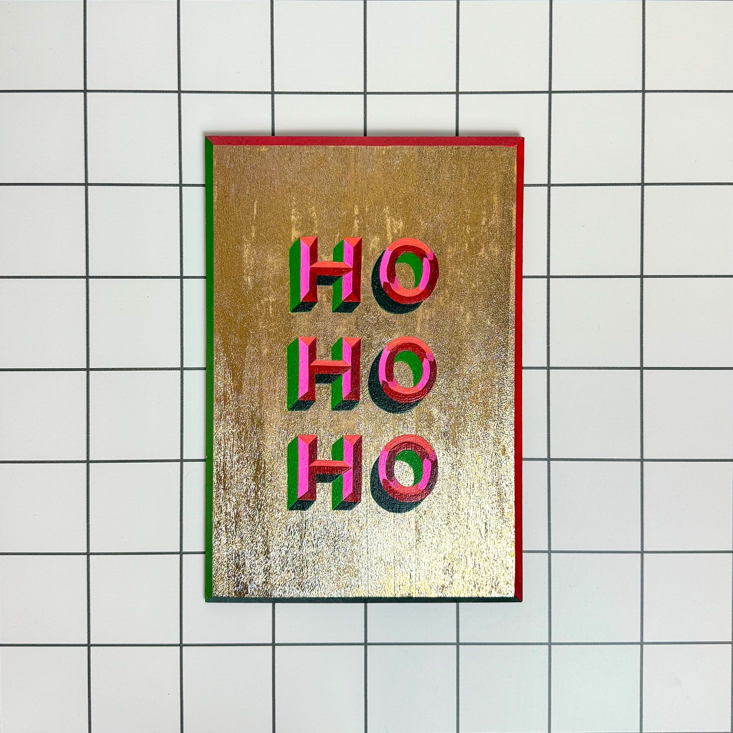 Front view - Stoofy's Festive hand-painted “HO HO HO” Christmas sign-writing artwork – joyful, one-of-a-kind holiday décor with glitter details. Perfect for mantelpieces, shelves or walls at Christmas or year round. Maximalist interiors