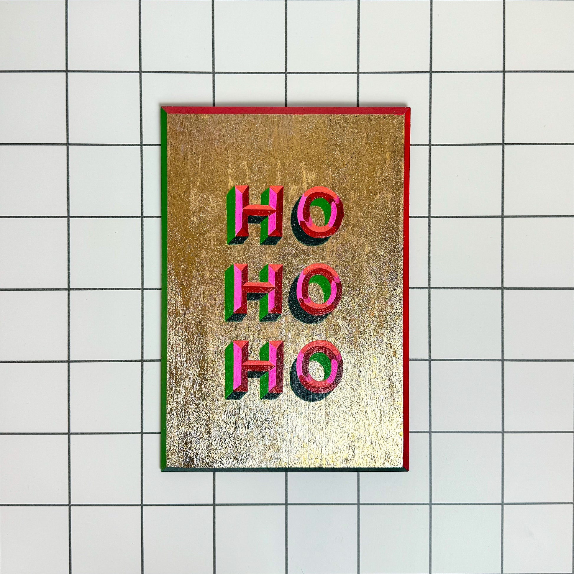 Front view - Stoofy's Festive hand-painted “HO HO HO” Christmas sign-writing artwork – joyful, one-of-a-kind holiday décor with glitter details. Perfect for mantelpieces, shelves or walls at Christmas or year round. Maximalist interiors