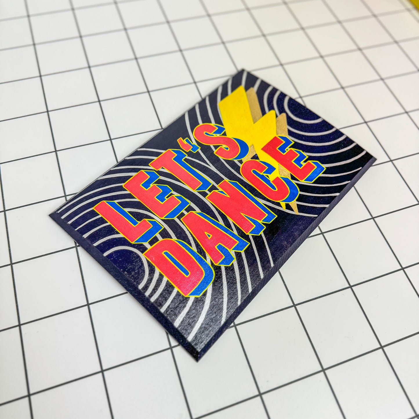 Alternative view of Stoofy's David Bowie inspired, “Let’s Dance” contemporary artwork with sign-writing. A lively, hand-painted sign inspired by the spirit of dance and celebration. With its dynamic colours and expressive typography, it adds a playful touch to any space. Human-made art by Stoofy.