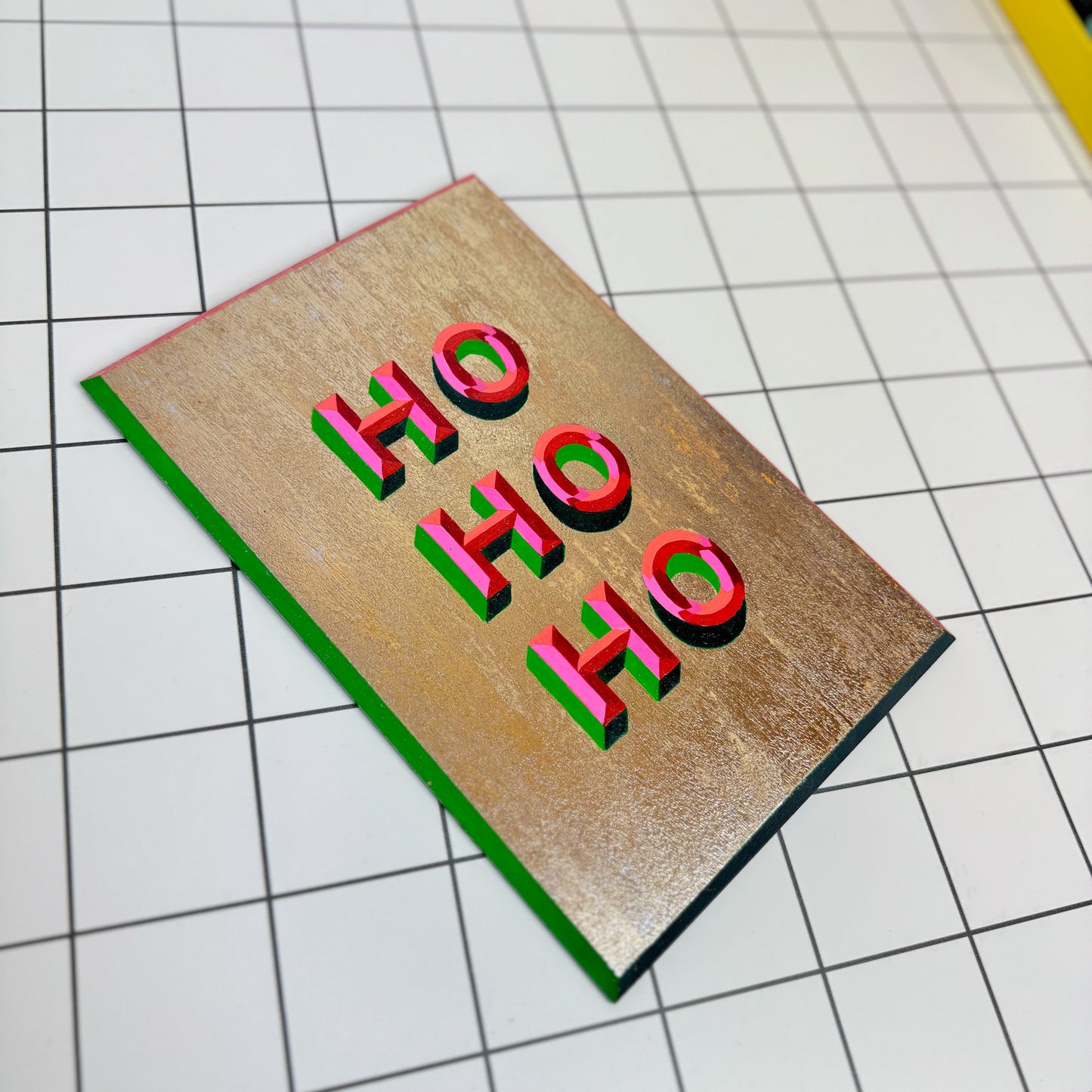 Alternative view of Stoofy's festive hand-painted “HO HO HO” Christmas sign-writing artwork – joyful, one-of-a-kind holiday décor with gold metal leaf and bevelled font details. Perfect maximalist homes. Human-made by Stoofy