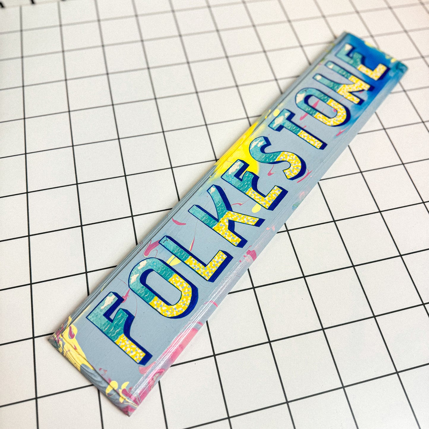 Alternative view of Stoofy's colourful hand-painted wooden sign, reading “Folkestone” in retro-style typography by contemporary UK artist, Stoofy.