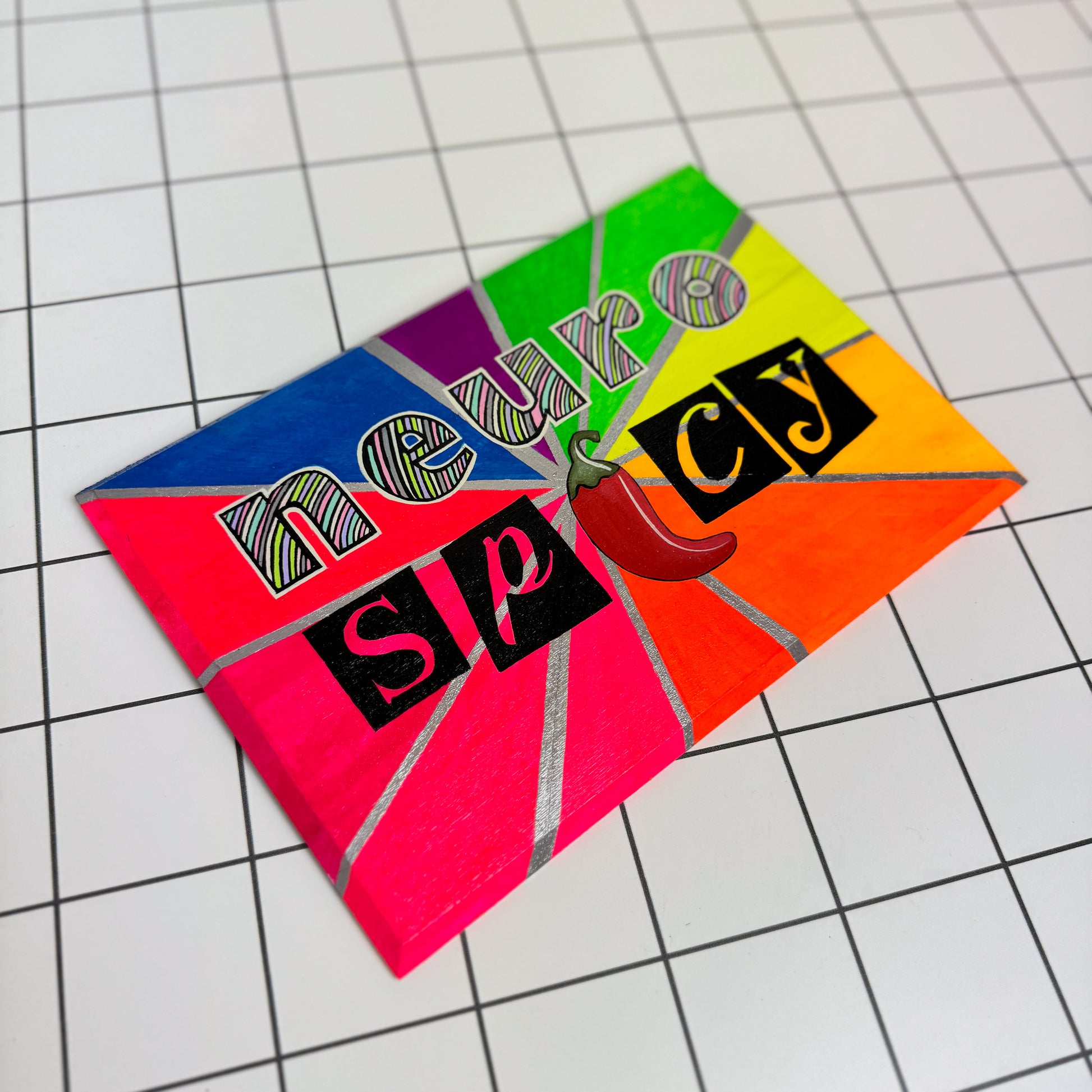 Neuro Spicy sign with pastel lettering and silver accents on a rainbow spectrum background, hand-painted with a glossy finish.