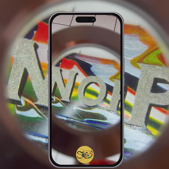 Hand-painted 'NOPE TO TAUPE' sign being looked at underneath a magnifying glass, highlighting yhr bold, colourful, glittery lettering, background and shiny gloss finish.