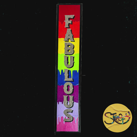 “Fabulous” is a striking, vertical hand-painted sign adorned with a rainbow of bright, dripping colours and glittering lettering. It's a bold statement piece that celebrates individuality and joy. By The Stoofy Store