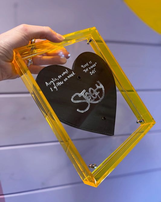 Transparent back of Love Will Tear Us Apart framed artwork showing acrylic frame by Stoofy